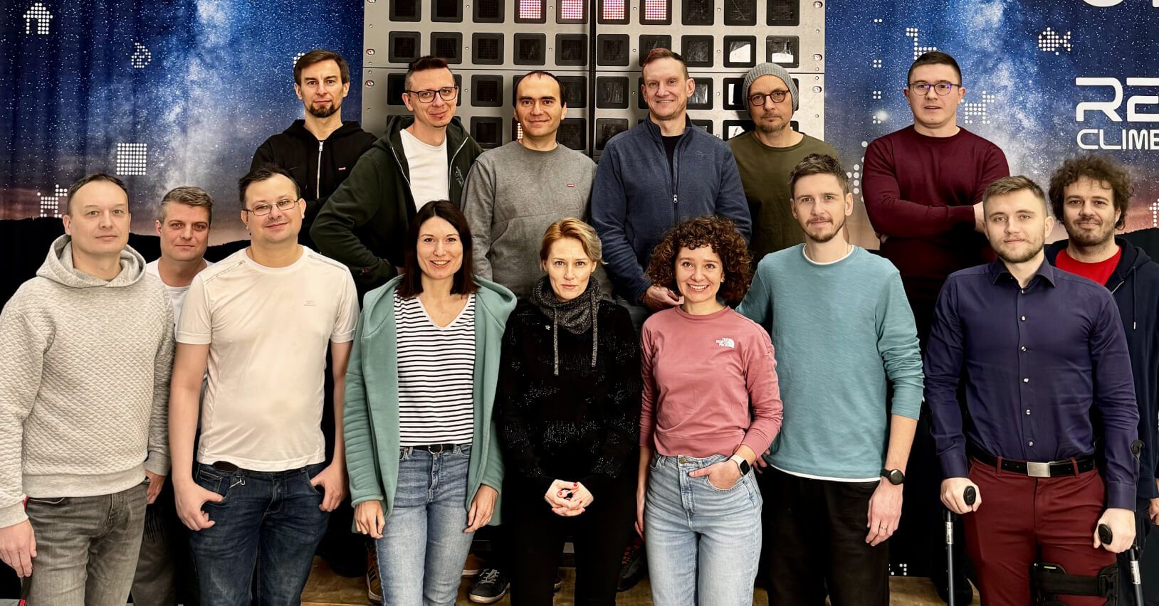 Zesp&oacute;ł Reclimb na tle interaktywnej ścianki wspinaczkowej Skywall