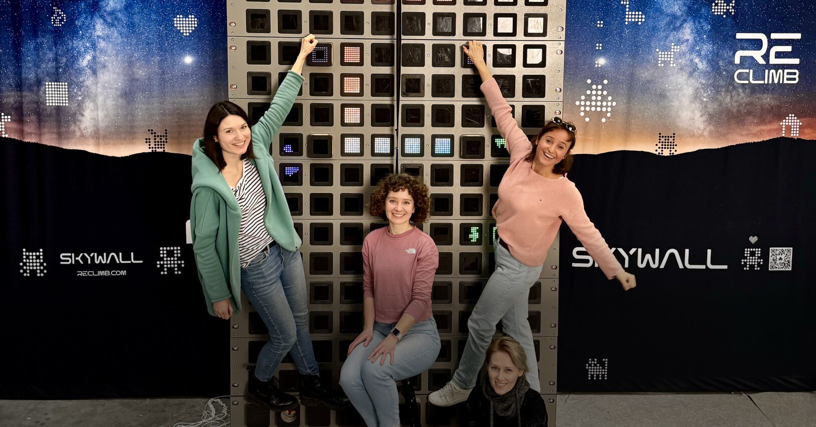 Zesp&oacute;ł Reclimb na tle ścianki wspinaczkowej Skywall