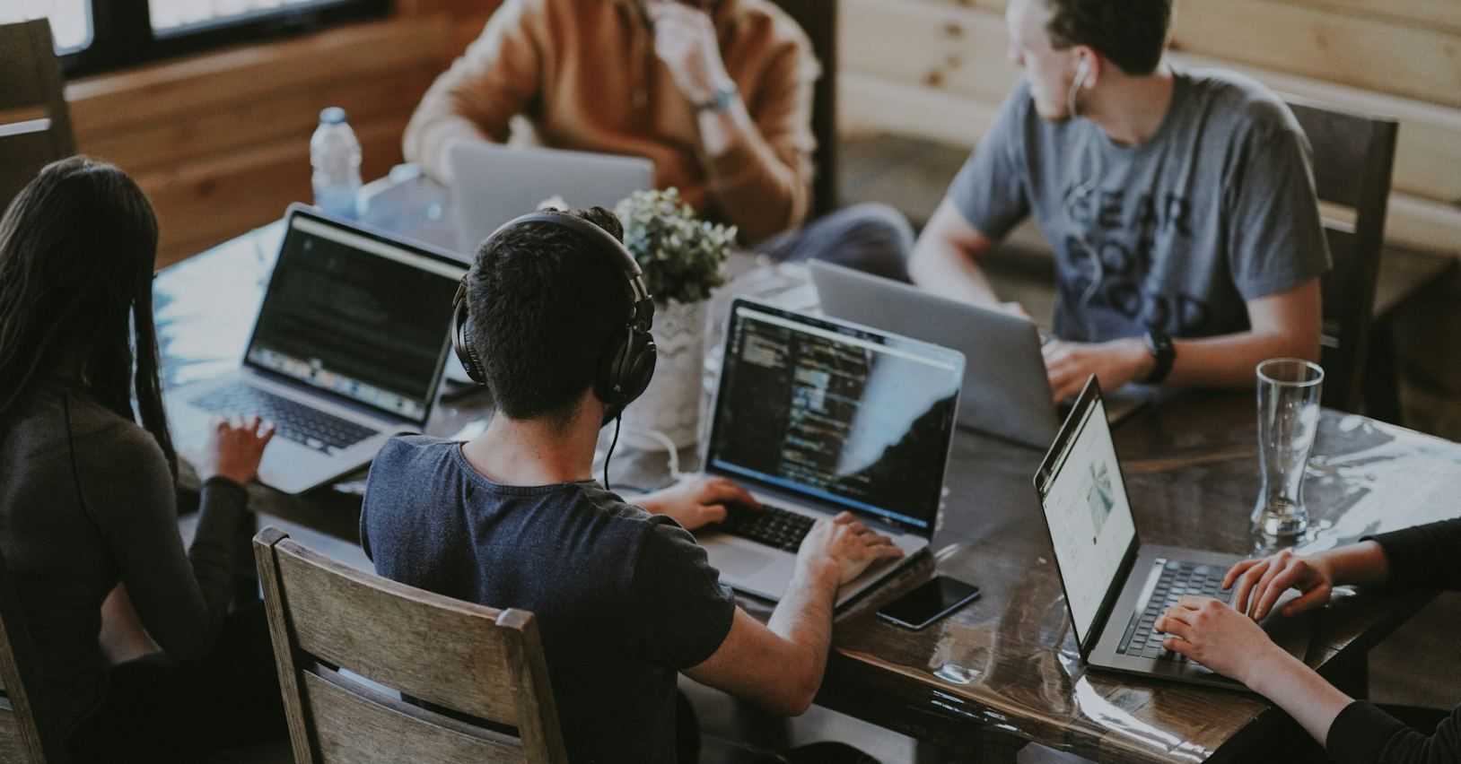 Zespół startupu pracujący na laptopach przy wspólnym stole